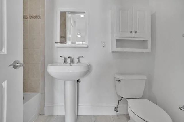 a bathroom with a toilet sink and mirror