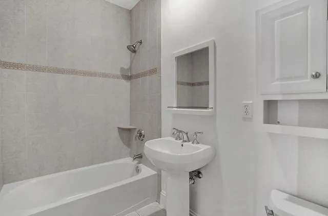 a white bath tub sitting next to a white sink