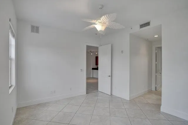 an empty room with fan and entrance