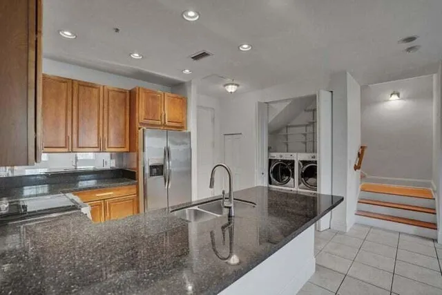 a kitchen with granite countertop a sink and a stove top oven