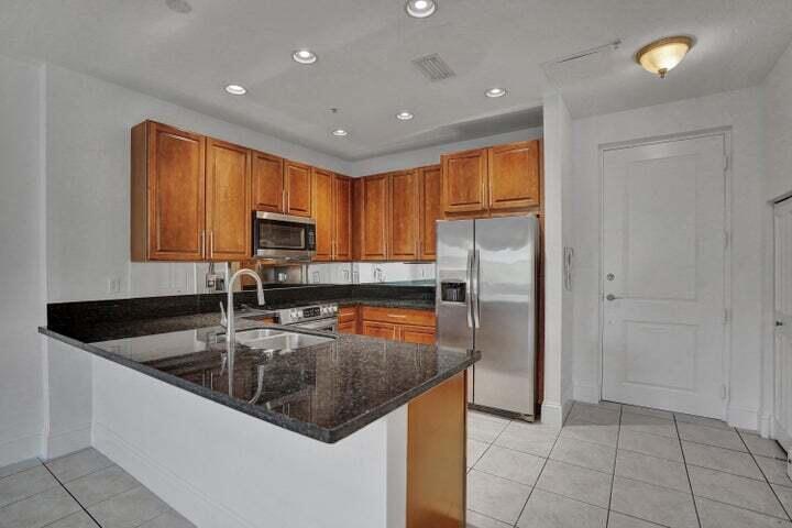 3120 East Latitude Circle, Unit 309 Delray Beach, FL 33483 - Photo 6 of 32 a kitchen with a refrigerator a sink a stove a microwave and cabinets