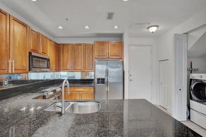 3120 East Latitude Circle, Unit 309 Delray Beach, FL 33483 - Photo 7 of 32 a view of a kitchen with a sink dishwasher a refrigerator and a microwave
