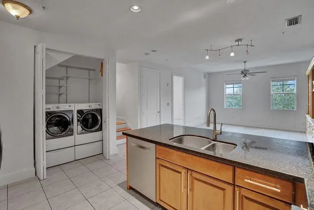 a kitchen with granite countertop a sink and white cabinets