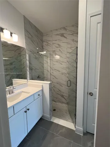 a bathroom with a shower sink and mirror
