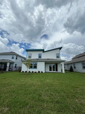 a view of a house with a big yard and large trees