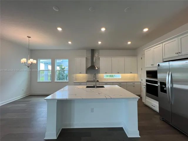 a kitchen with kitchen island a counter space a sink appliances and a window
