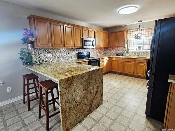 a kitchen with granite countertop a sink cabinets and window