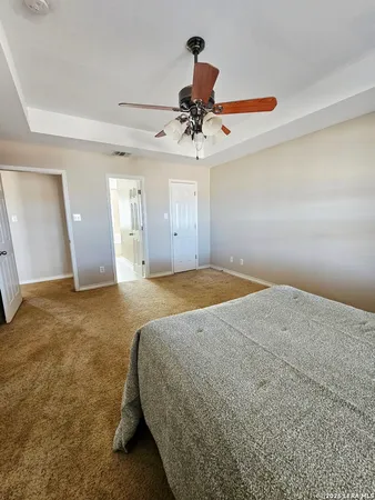 a spacious bedroom with a bed and cabinets