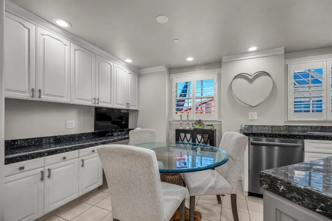 47 Surfside Avenue Surfside, CA 92649 - Photo 18 of 37 a kitchen with granite countertop a stove a sink a table and chairs in it