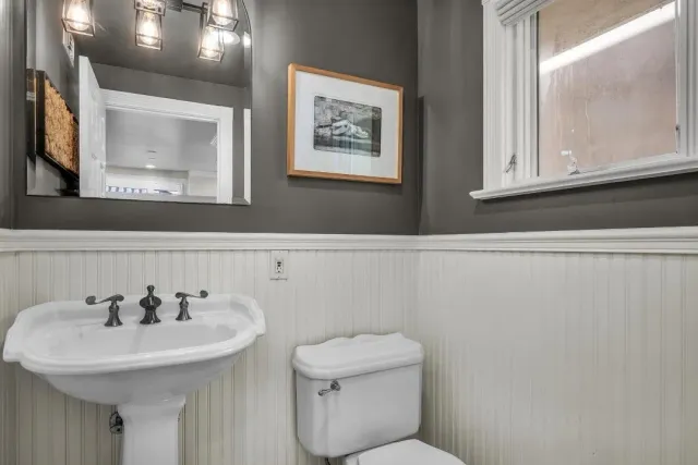 a bathroom with a toilet a sink and mirror