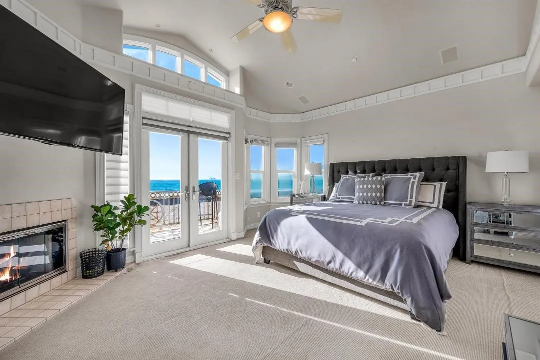 47 Surfside Avenue Surfside, CA 92649 - Photo 21 of 37 a bedroom with a bed and a fireplace