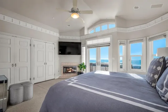 a spacious bedroom with a bed and a flat tv screen on dresser