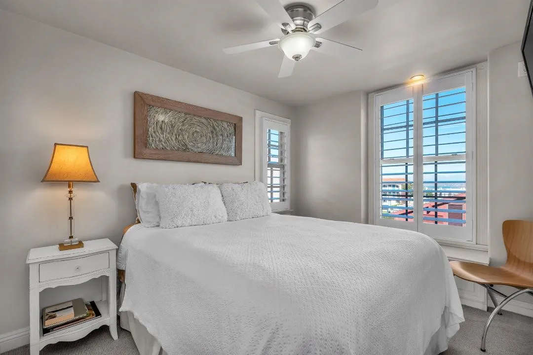 47 Surfside Avenue Surfside, CA 92649 - Photo 27 of 37 a bedroom with a bed and a lamp on table with window