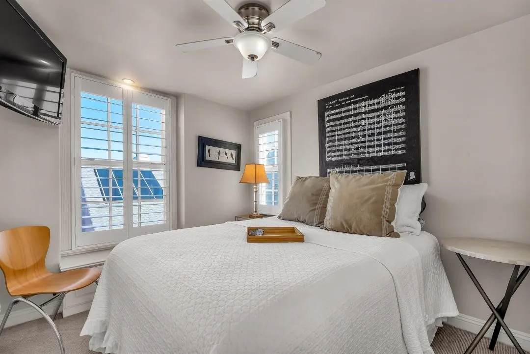 47 Surfside Avenue Surfside, CA 92649 - Photo 30 of 37 a bedroom with a bed and a chandelier