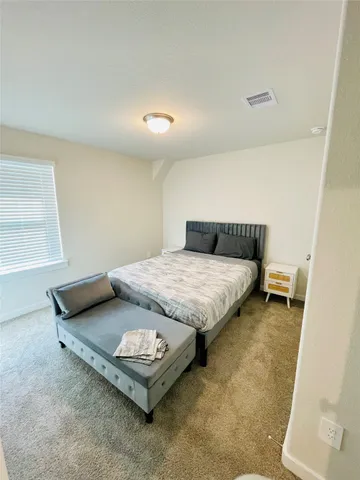 a bedroom with a bed and a window