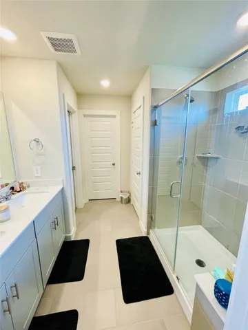 a bathroom with a tub shower sink and mirror