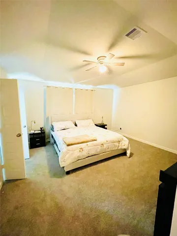 a spacious bedroom with a bed and a cabinets