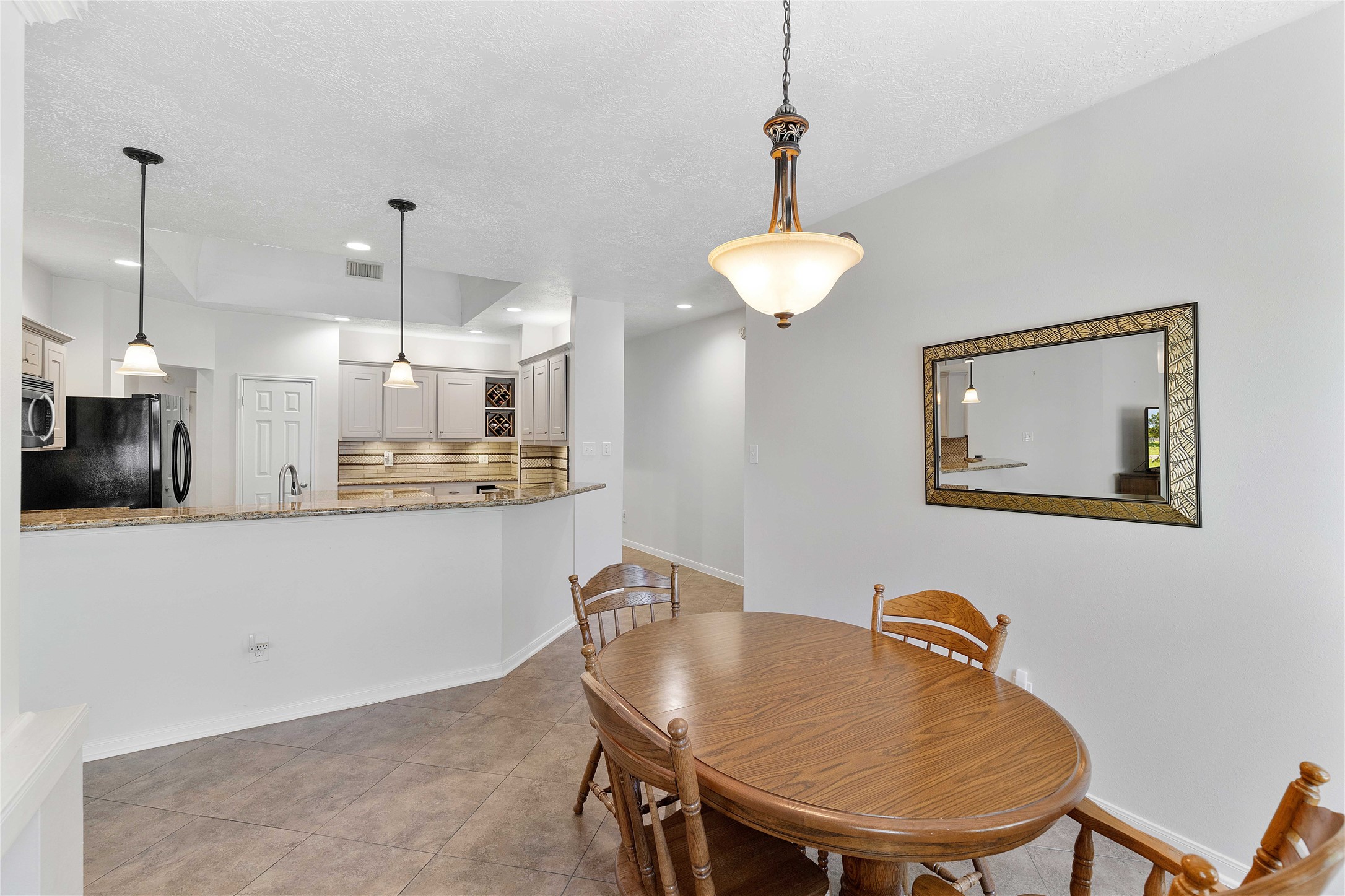 1707 Moston Drive Spring, TX 77386 - Photo 16 of 41 a kitchen with stainless steel appliances granite countertop a sink a refrigerator a stove a sink with a dining table and chairs