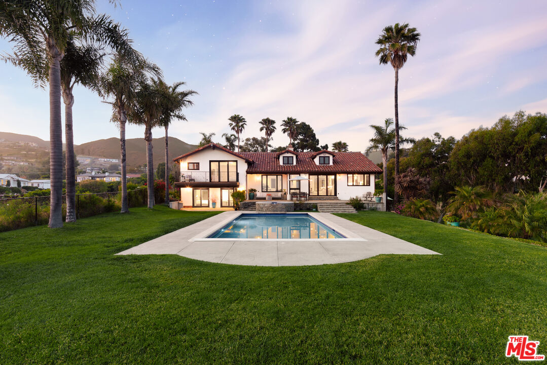 29660 Harvester Road Malibu, CA 90265 - Photo 2 of 45 a view of a house with a big yard and palm trees
