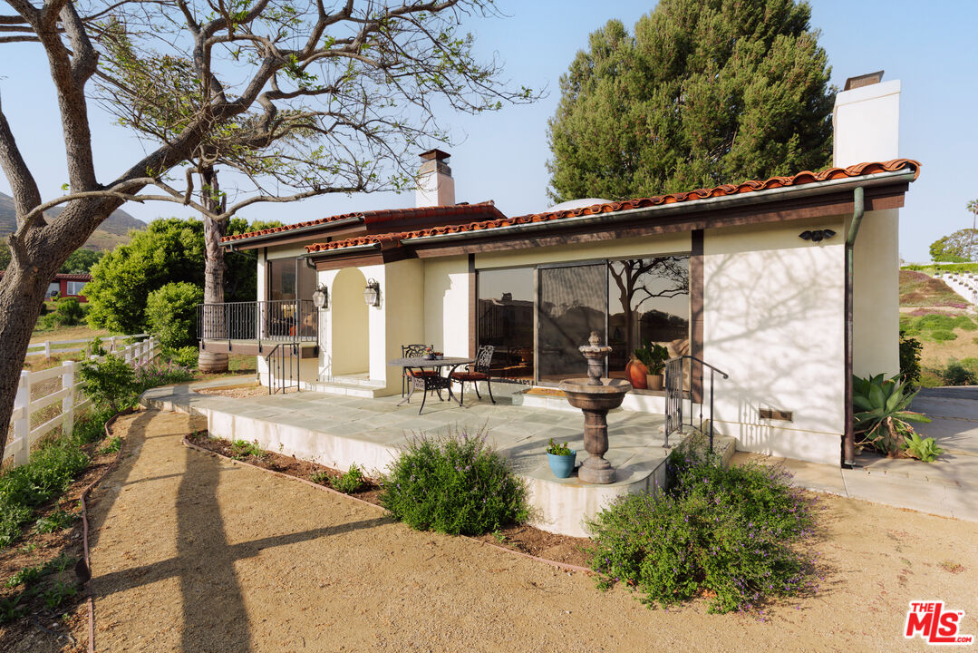 29660 Harvester Road Malibu, CA 90265 - Photo 23 of 45 a view of a patio with table and chairs potted plants and large tree