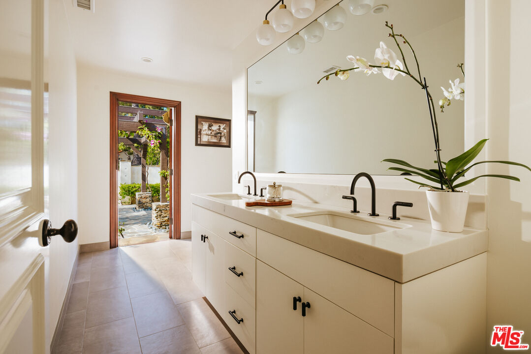 29660 Harvester Road Malibu, CA 90265 - Photo 28 of 45 a bathroom with a double vanity sink and mirror with bathtub