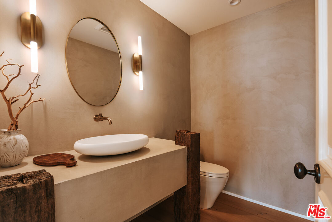 29660 Harvester Road Malibu, CA 90265 - Photo 30 of 45 a bathroom with a granite countertop sink and a mirror