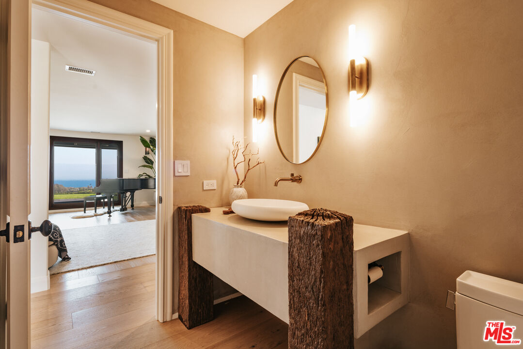 29660 Harvester Road Malibu, CA 90265 - Photo 31 of 45 a en suite bathroom with a granite countertop sink a mirror and bathtub