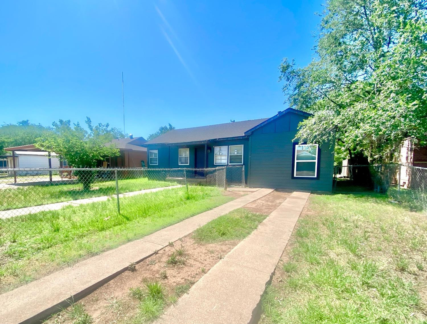 517 54th Street Lubbock, TX 79404 - Photo 3 of 16 a view of a house with a big yard potted plants and large tree