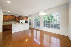 a view of a kitchen with kitchen island a sink wooden floor and a large window