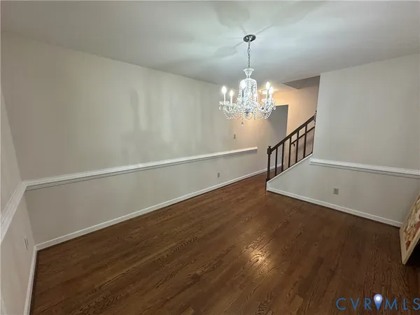 a view of an empty room with wooden floor and a fireplace