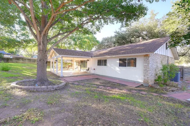 a view of a house with backyard and a tree