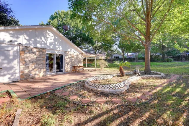 a view of a house with backyard and trees