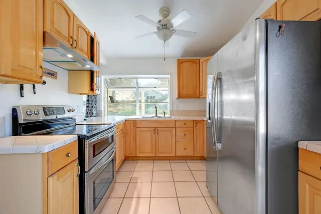 a kitchen with stainless steel appliances granite countertop a stove a sink and a refrigerator