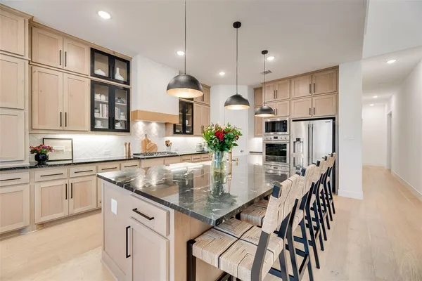 a kitchen with stainless steel appliances granite countertop a stove a sink a refrigerator and a granite counter tops