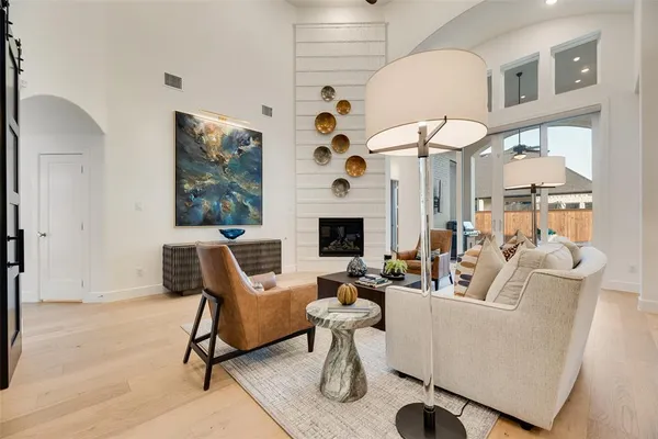 a living room with furniture a fireplace and a chandelier
