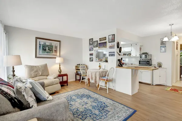 a living room with furniture and view of kitchen