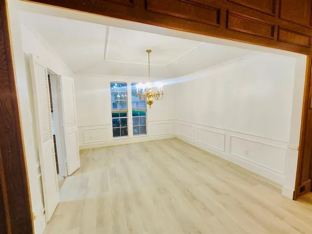 a view of a room with wooden floor and white walls