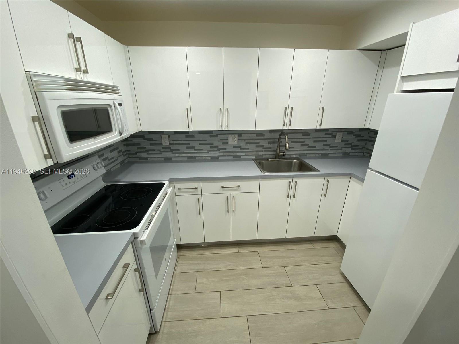 4805 Northwest 7th Street, Unit 10315 Miami, FL 33126 - Photo 1 of 22 a kitchen with a sink a stove and cabinets
