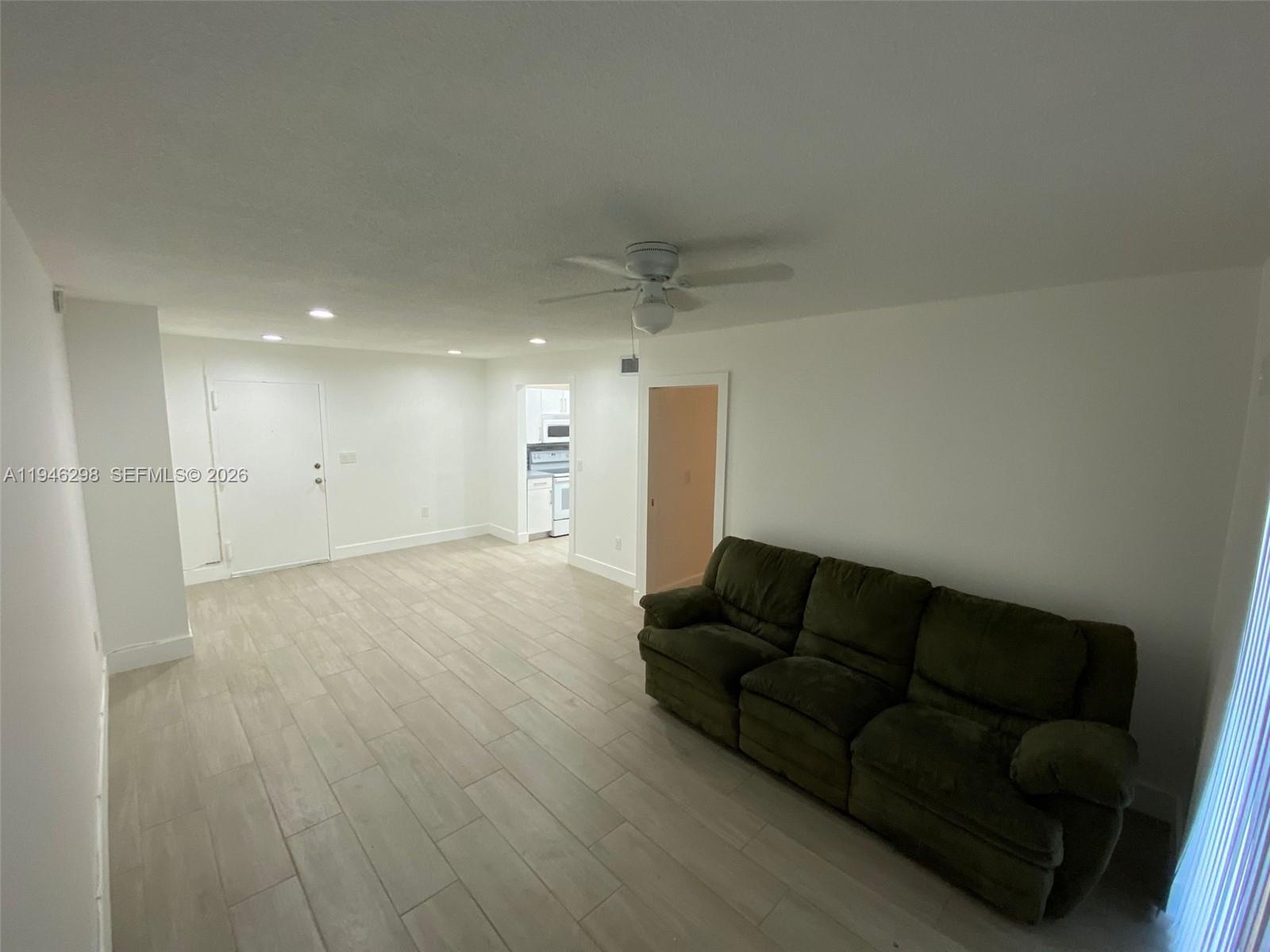 4805 Northwest 7th Street, Unit 10315 Miami, FL 33126 - Photo 6 of 22 a living room with furniture and a wooden floor