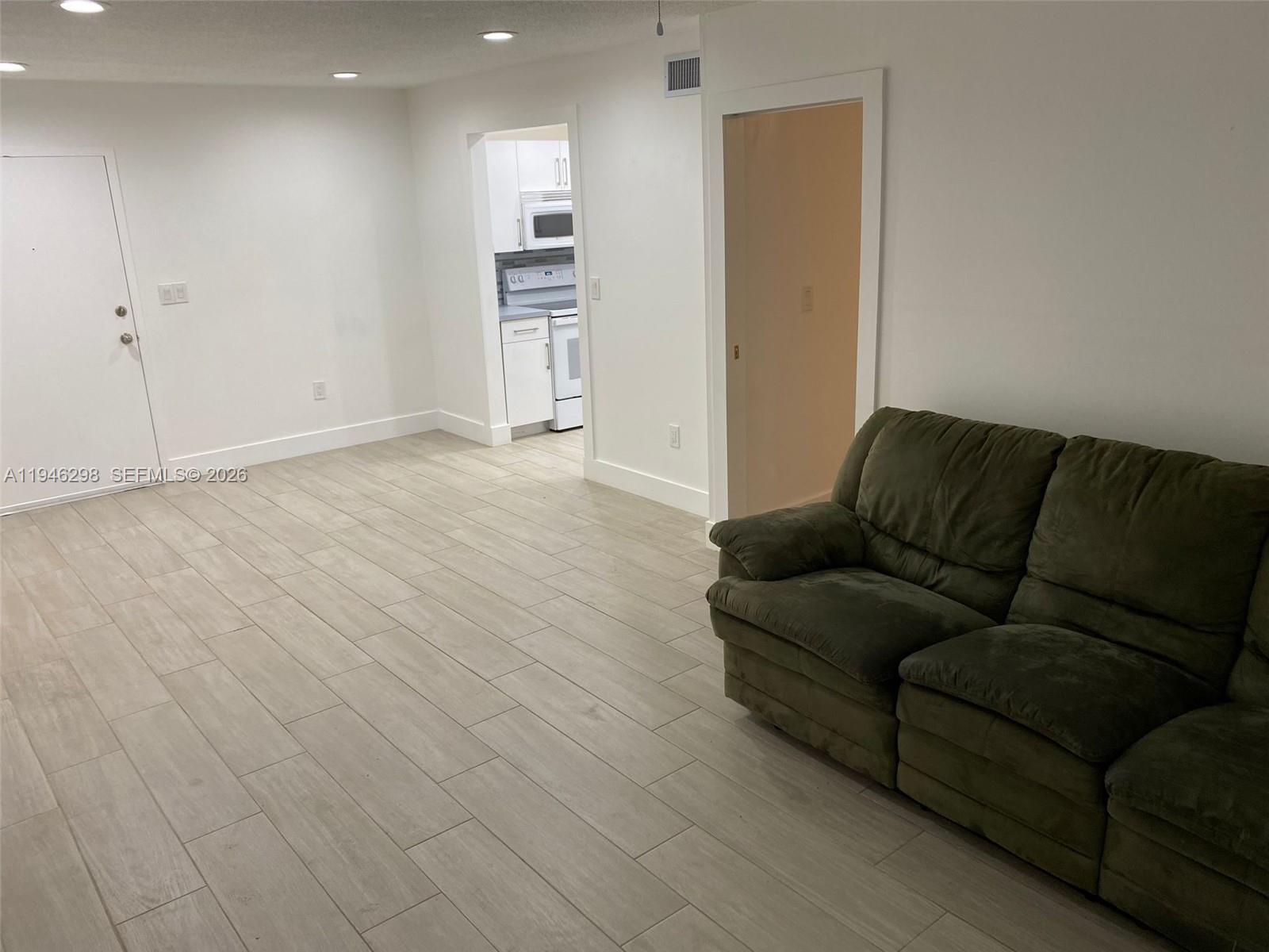 4805 Northwest 7th Street, Unit 10315 Miami, FL 33126 - Photo 7 of 22 a living room with furniture and a wooden floor