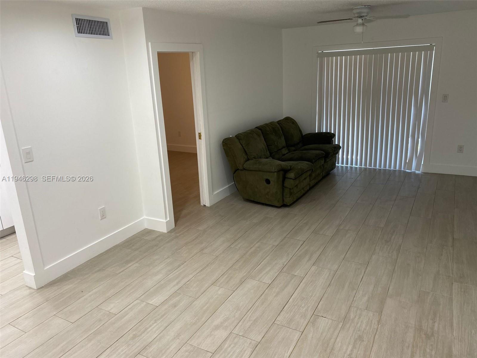4805 Northwest 7th Street, Unit 10315 Miami, FL 33126 - Photo 8 of 22 an empty room with wooden floor and furniture