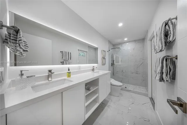 a bathroom with a double vanity sink a toilet and a mirror