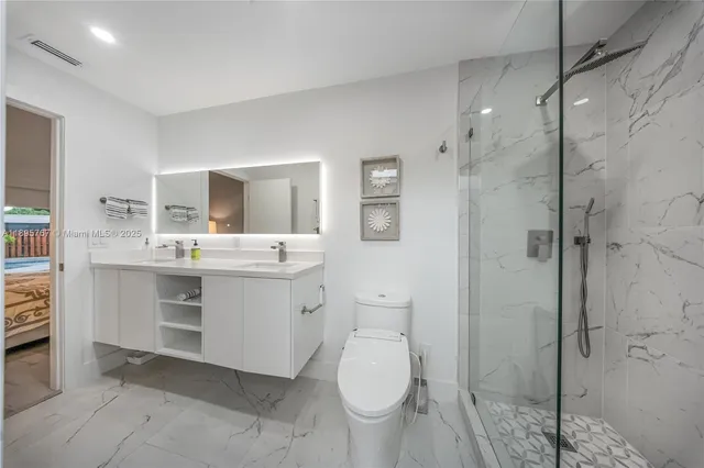 a bathroom with a sink toilet vanity and shower