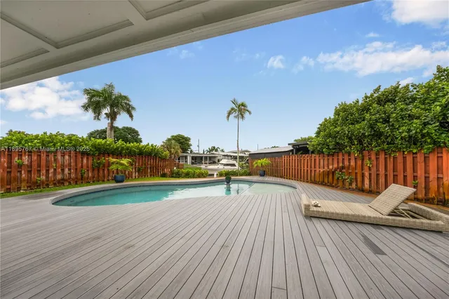 a view of a deck with wooden floor and fence with a table and chairs