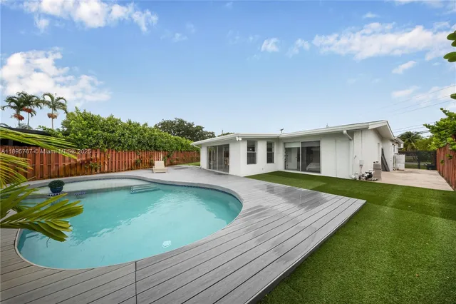a view of a house with pool fire pit and chairs