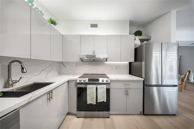 a kitchen with appliances a sink and a cabinets