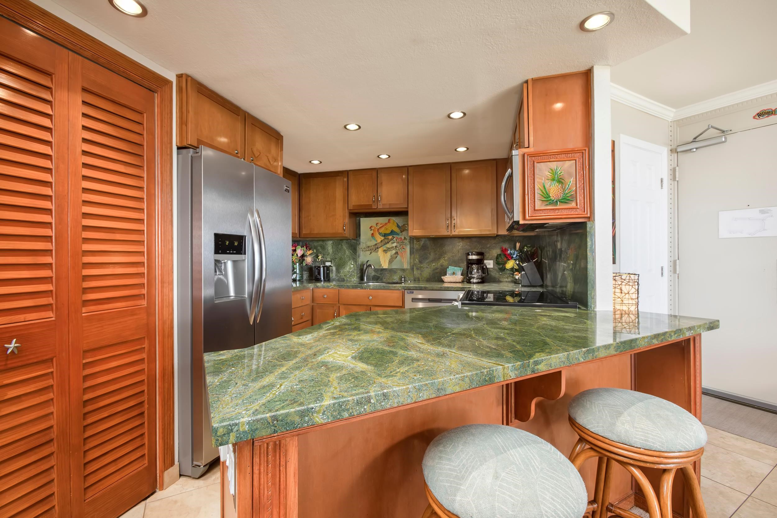 3445 Lower Honoapiilani Road, Unit 304 Lahaina, HI 96761 - Photo 11 of 41 a room with stainless steel appliances granite countertop a sink refrigerator and chairs