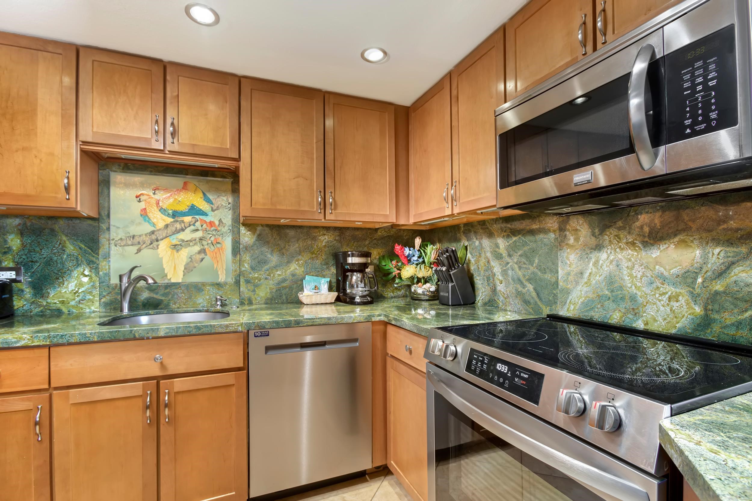 3445 Lower Honoapiilani Road, Unit 304 Lahaina, HI 96761 - Photo 12 of 41 a kitchen with granite countertop a stove a sink and dishwasher wooden cabinets with granite countertops