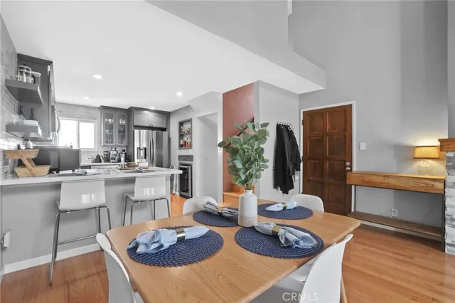 a living room with furniture a large window and dining table