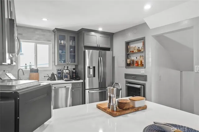 a kitchen with stainless steel appliances kitchen island granite countertop a refrigerator a sink a stove with wooden floor